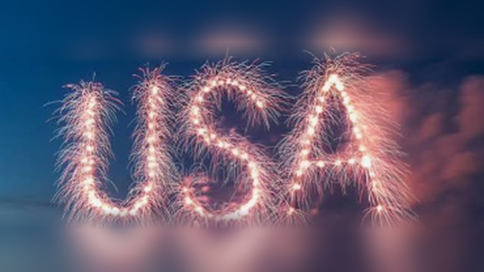 Fireworks forming the letters USA against a dusk sky.